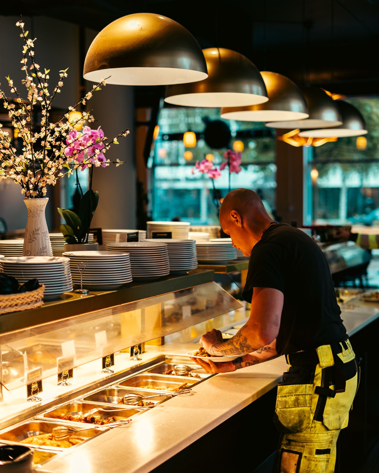 Buffédisken hos Asian BBQ Bistro i Täby med nylagade rätter under mässingslampor