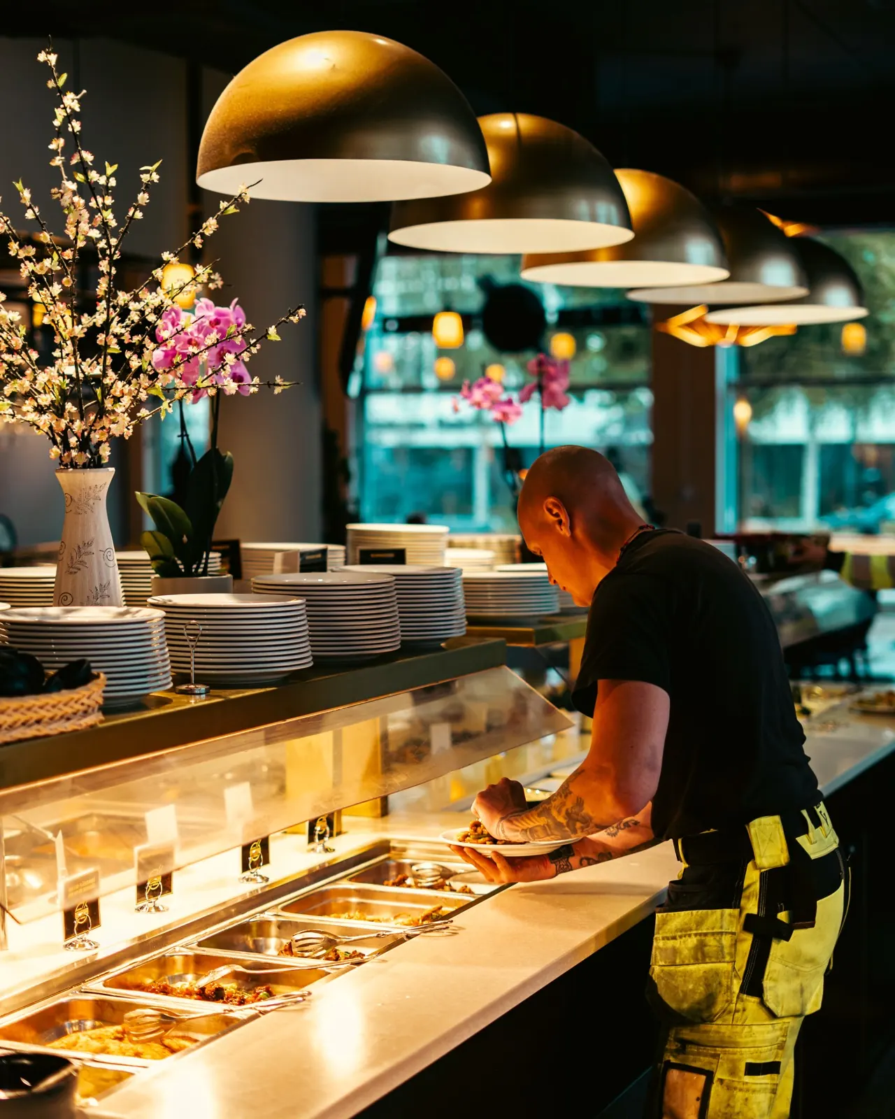 Buffédisken hos Asian BBQ Bistro i Täby med nylagade rätter under mässingslampor